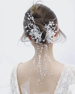 Détail d'une pince à cheveux de mariée artisanale avec perles blanches et pompons