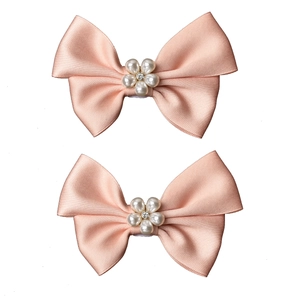 Détail de deux clips de chaussures de mariée en satin avec perles et strass