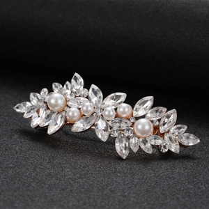 Detailed close-up of marquise rhinestone flower hair clip with pearls on black background