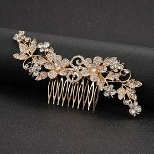 Elegant gold bridal hair comb featuring rhinestone flowers and symmetrical leaf designs