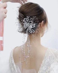 Détail d'un accessoire cheveux de mariée avec perles faites main et pompons sur chignon