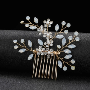 Vue macro d'un peigne de mariée avec fil doré, cristaux et perles opales blanches