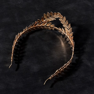 Macro detail of Baroque golden metal leaf headband with intricate laurel leaf textures
