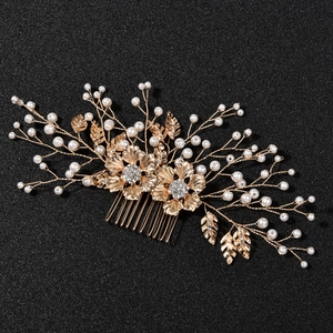 Détails d'un peigne à cheveux de mariée avec fleurs dorées, perles et strass brillants