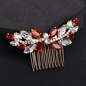 Detail of a gold bridal hair comb with elegant red and white marquise-cut rhinestones