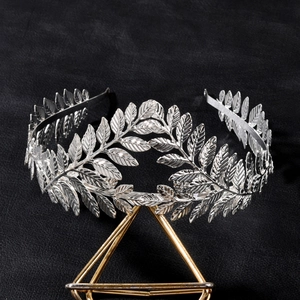 Baroque silver laurel leaf crown headband with detailed textures on a display stand