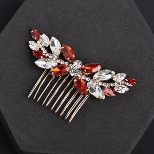 Detail of bridal hair comb with red and clear rhinestones on a gold metal base
