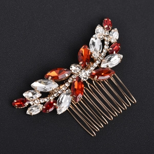 Macro detail of bridal hair comb with red and clear crystals in gold alloy setting