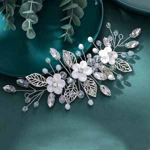 Detailed macro view of bridal hair comb with white flowers, silver leaves and crystals