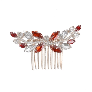 Detailed shot of red and white crystals set on a gold bridal hair comb accessory