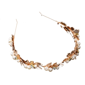 Detailed close-up of golden leaf bridal headband with white pearls and sparkling crystals
