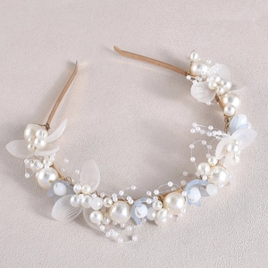 Détail d'un serre-tête de mariée avec perles florales blanches et monture dorée