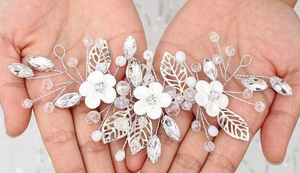 Detail of bridal hairpiece with white flowers, silver leaves, pearls and crystals