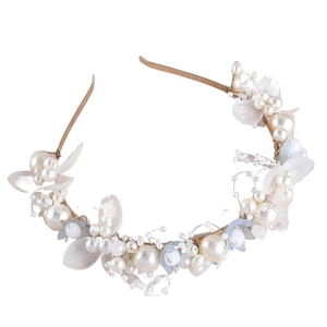 Détail d'un serre-tête de mariée fait main avec fleurs blanches et perles bleues