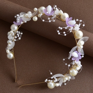 Détail de vigne de cheveux de mariée avec pétales mauves et perles sur fond marron