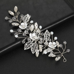 Detailed view of bridal hair piece with silver leaves, white flowers, and crystals