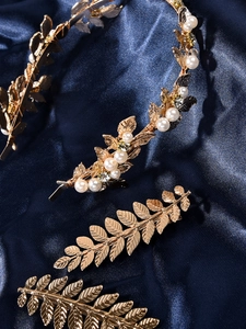 Detail of baroque gold leaf bridal headband with pearls on blue silk background
