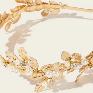 Detail of golden metal leaves with white pearls and rhinestones on a bridal headband