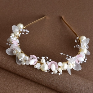 Vue détaillée du serre-tête de mariée avec fleurs blanches, perles et fil doré
