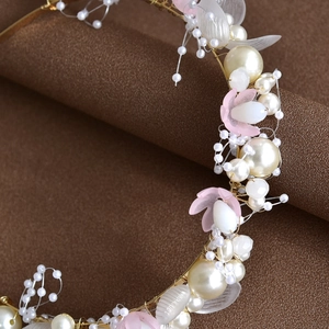 Détail d'un serre-tête de mariée fait main avec perles blanches et fil doré fleuri