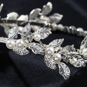 Detailed macro view of silver alloy leaf hairband with delicate pearls and rhinestones