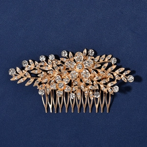 Exquisite gold bridal hair comb with rhinestone flowers and leaves on blue background