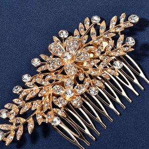 Detailed close-up of golden bridal hair comb with rhinestones on dark blue background