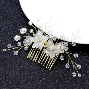Close-up of golden floral hair comb with frosted white petals and delicate pearls