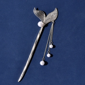 Detail of silver mermaid tail hair stick with tassels, pearls and shiny rhinestones