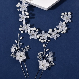 Dettaglio dei petali in acrilico e perle sintetiche su un set di tralci per capelli da sposa