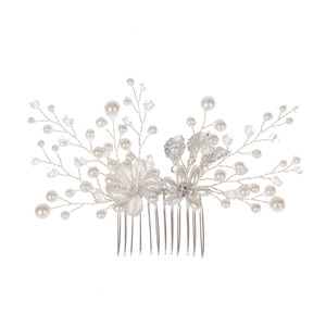Close-up of handmade bridal hair comb with gold leaves, pearls, and crystals for weddings