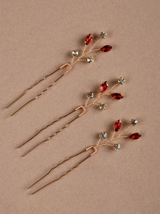 Détail de trois épingles à cheveux dorées avec pierres marquises rouges et cristaux