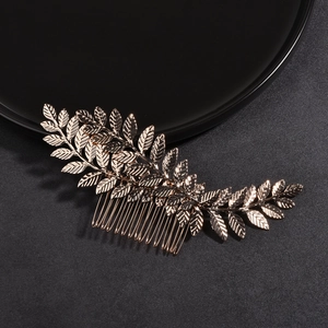 Detail of golden leaf hair comb with intricate vein texture on black display surface