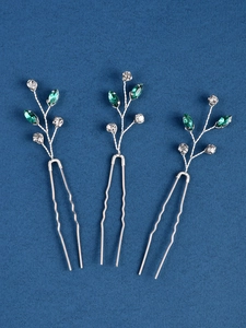 Détail de trois épingles à cheveux de mariée avec fil d'argent et strass émeraude