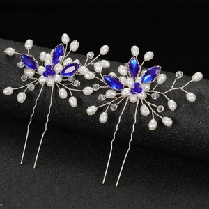 Elegant pair of blue marquise crystal and white pearl bridal hair pins on a black stand