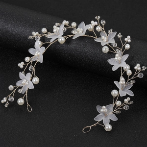 Detail von Braut-Haarschmuck mit weißen Harzblüten und Perlen auf goldenem Draht