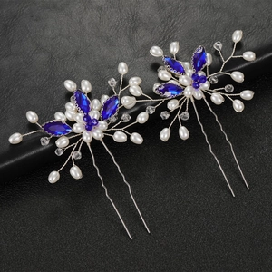 Detailed close-up of handmade bridal hair pins with blue marquise crystals and white pearls