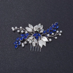 Détail de strass marquise bleus, feuilles argentées et perles sur un peigne de mariée