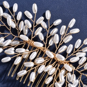 Détail macro d'un peigne de mariée en fil doré et perles blanches sur tissu bleu foncé