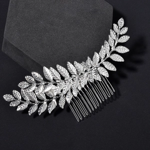 Detailed silver leaf bridal hair comb with textured metallic leaves on a black background