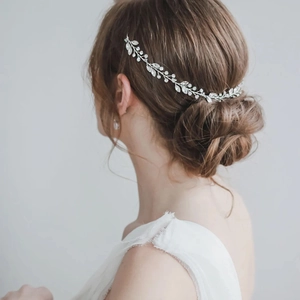 Elegante vite per capelli da sposa con foglie d'argento e cristalli su chignon