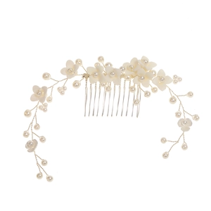 Détail d'un peigne de mariée avec fleurs en céramique blanche et perles faites à la main