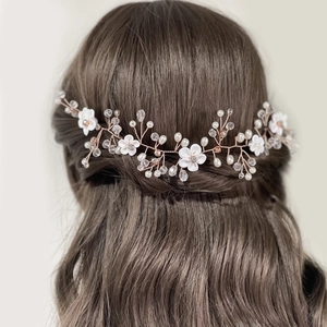 Vue détaillée d'une mariée portant une vigne de cheveux en or rose avec fleurs en céramique