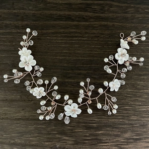 Détail de vigne à cheveux mariée or rose avec fleurs blanches, perles et cristaux
