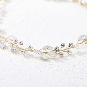 Dettaglio fascia da sposa con cristalli opale e design floreale in filo d'oro