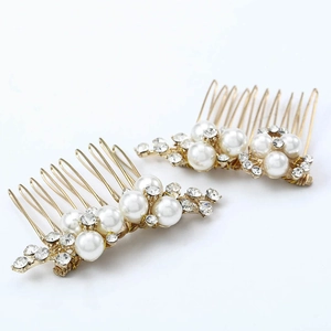 Dettaglio di pettini per capelli dorati con perle bianche e strass brillanti e lucidi
