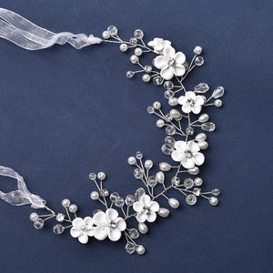 Bandeau de mariée élégant avec fleurs en tissu, cristaux et perles sur fond bleu