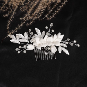 Handmade bridal hair comb with white ceramic flowers, silver leaves, and pearls