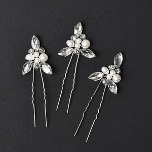 Détail d'épingles à cheveux de mariée en U avec fleurs argentées, perles et cristaux marquise