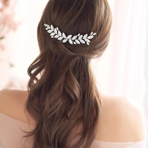 Peigne à cheveux argenté pour mariée avec feuilles en cristal sur une coiffure relevée